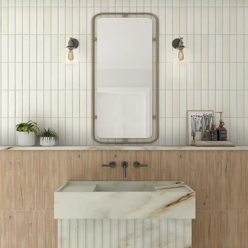 Daltile Artcrafted Coconut ceramic tile set vertically around a bathroom mirror above a stone sink in a manufacturer scene