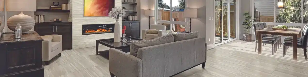 Daltile Articulo travertine-look floor tile through a living and dining room with a wave-textured fireplace wall in a manufacturer scene