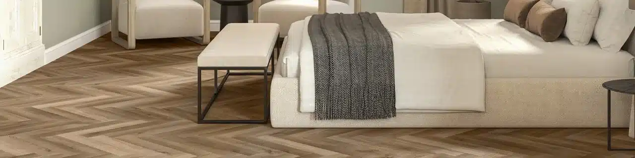 Daltile Asher Bend Lodge luxury vinyl flooring in a herringbone pattern in a manufacturer bedroom scene