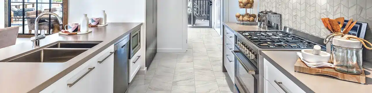 Daltile Famed Diamond marble-look porcelain floor between white kitchen cabinets in a manufacturer room scene