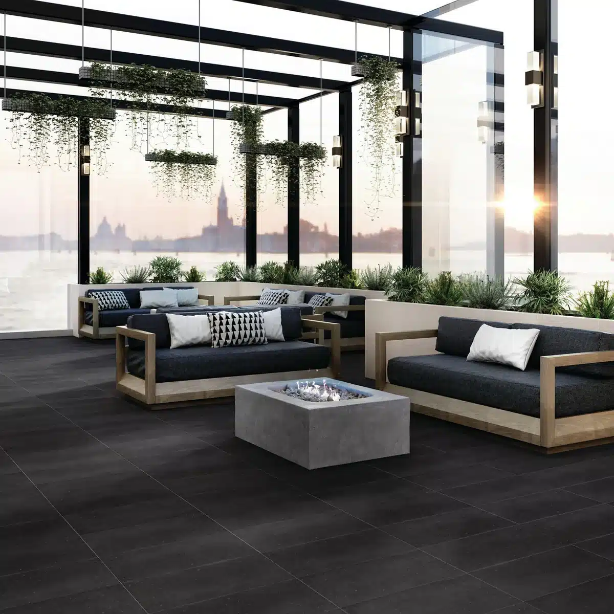 Daltile Harmonist Aura dark porcelain floor beneath wood-framed sofas and a fire table in a glass-enclosed manufacturer lounge scene
