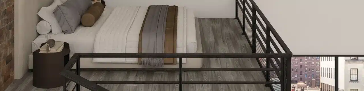 Daltile Harper's Place Farmhouse wood-look luxury vinyl plank around a bed and black railing in a manufacturer loft scene