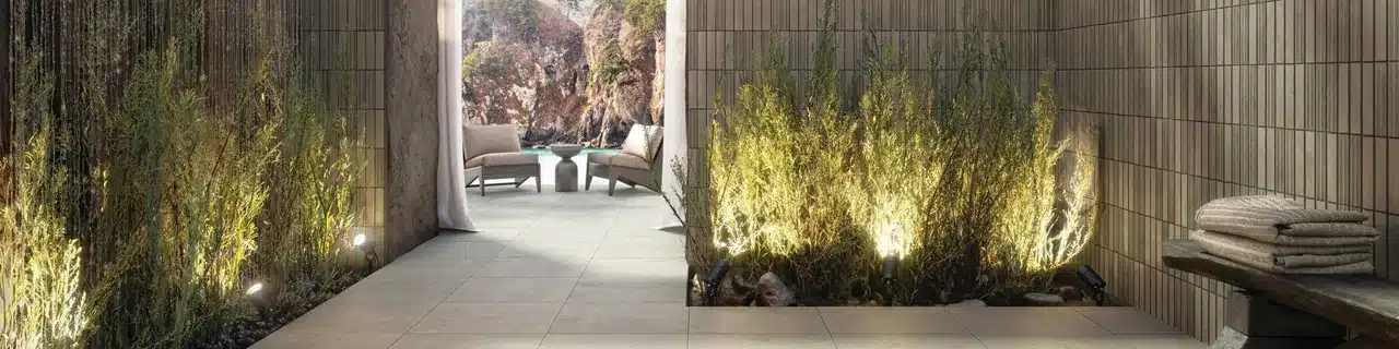 Daltile Indoterra Riverbed porcelain floor and textured walls beside planted beds in a manufacturer spa-like interior scene