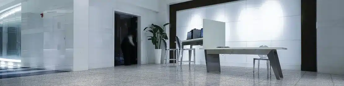 Daltile Modernist Pearsall Grey terrazzo-look porcelain floor beneath a desk and chairs in a manufacturer interior scene