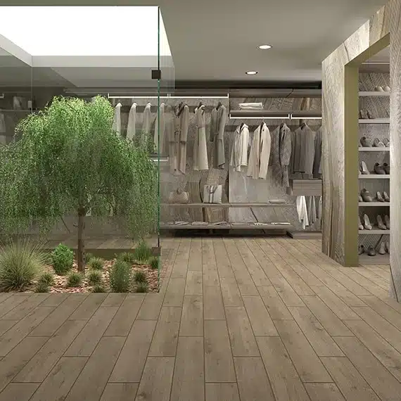 Daltile Sleigh Creek wood-look porcelain plank floor around a planted display and clothing racks in a manufacturer boutique scene