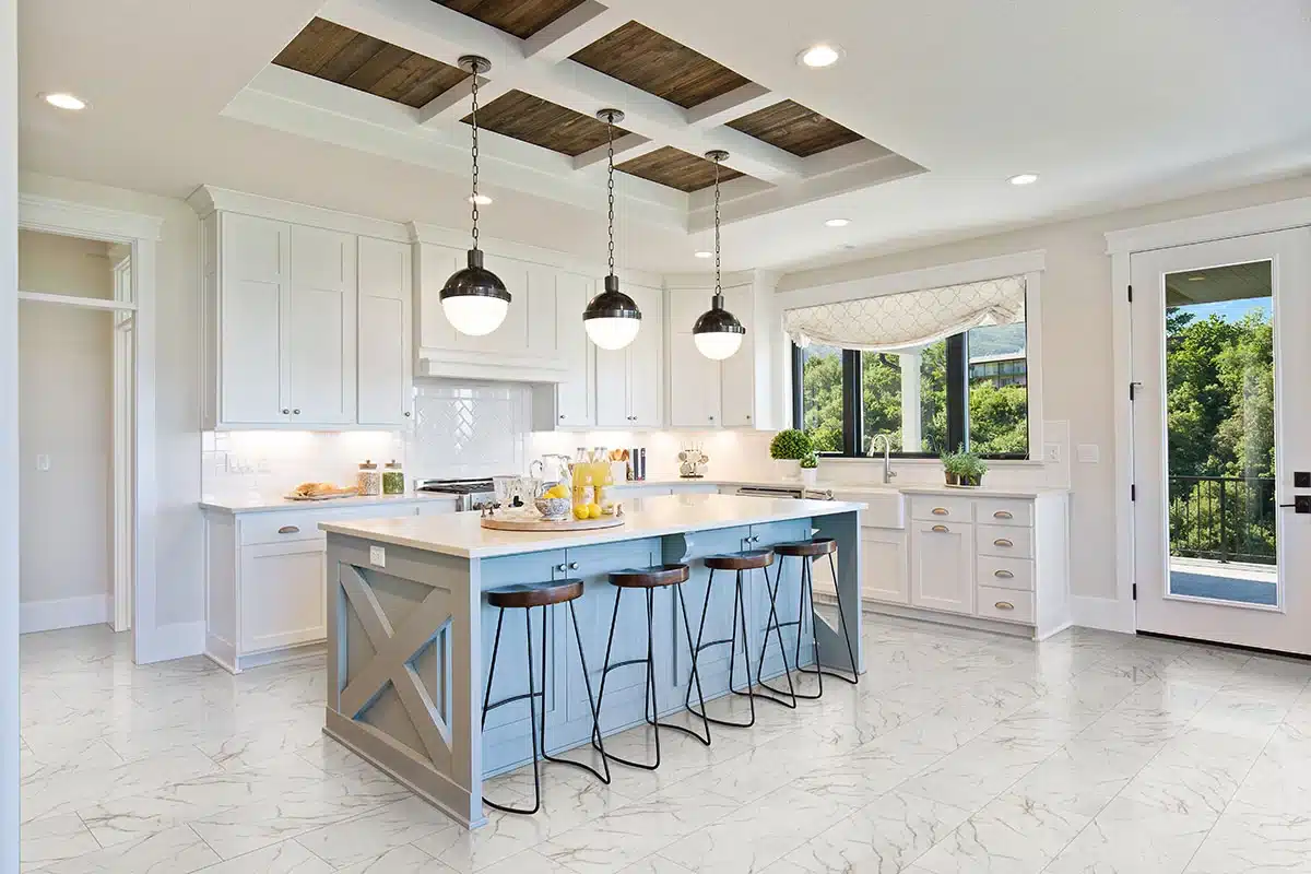 MSI Kaya Calacatta Lucca marble-look porcelain floor around a blue island in a manufacturer kitchen scene