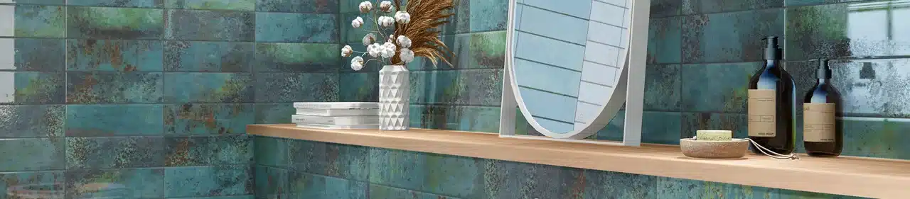 MSI Marza blue-green glossy ceramic wall tile behind a mirror and wood shelf in a manufacturer bathroom scene