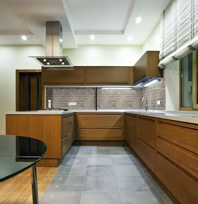 MSI Silver Travertine honed beveled subway backsplash beneath wood kitchen cabinets in a manufacturer room scene